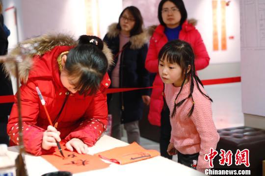 孩子在書寫春聯(lián)。 殷立勤 攝