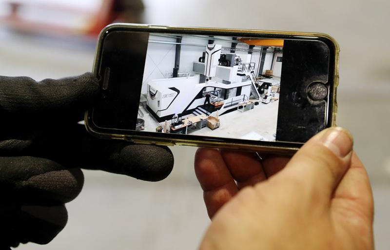 德國工程師馬丁·霍爾茨海德在安裝現場用手機展示“金牛座”龍門銑床安裝完成后的效果圖